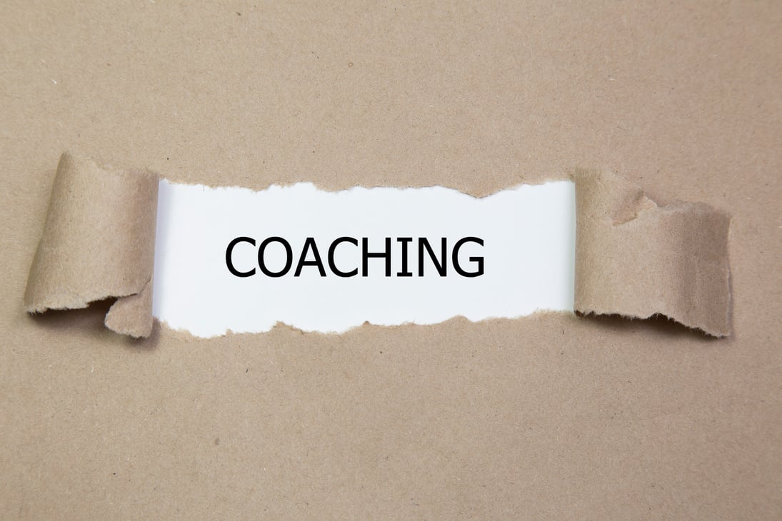 COACHING written under torn paper